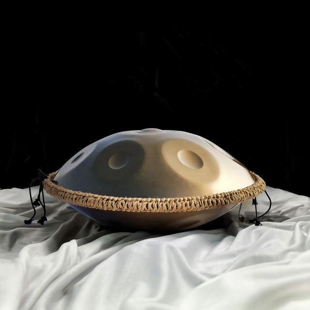 A golden handpan decorated with braided rope belongs to Handpanuni's Origin Series